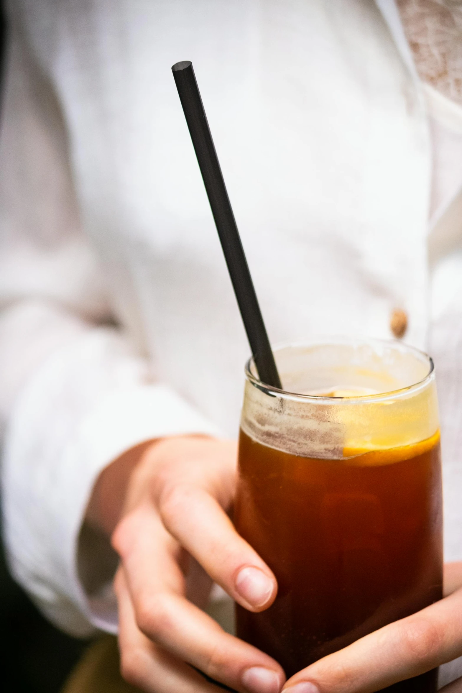 a woman is holding a drink with a straw in it