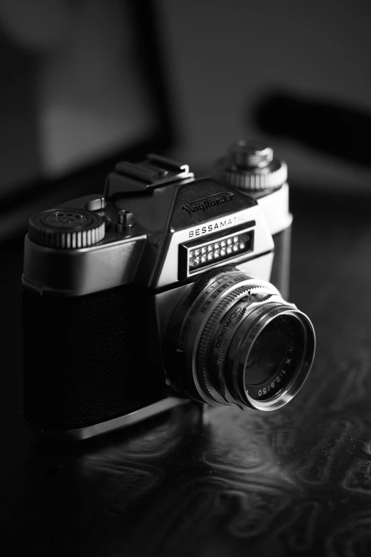 an old style camera sitting on top of a wooden table