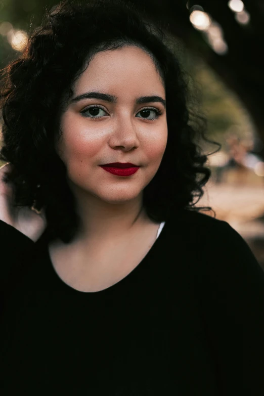 a woman in black with red lips is staring at the camera