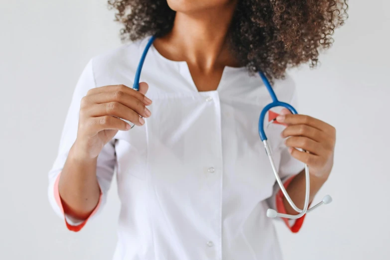 a woman in a white lab coat holds two heart shaped glasses up to her chest