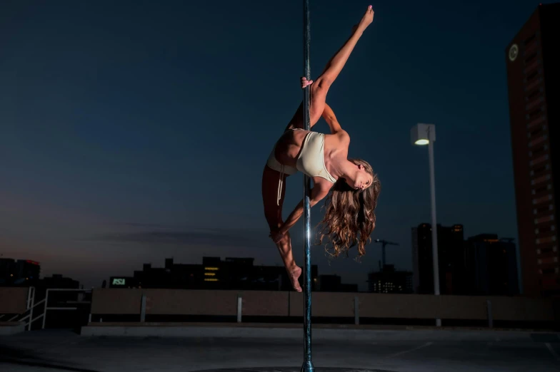 a woman on a pole doing an aerial trick