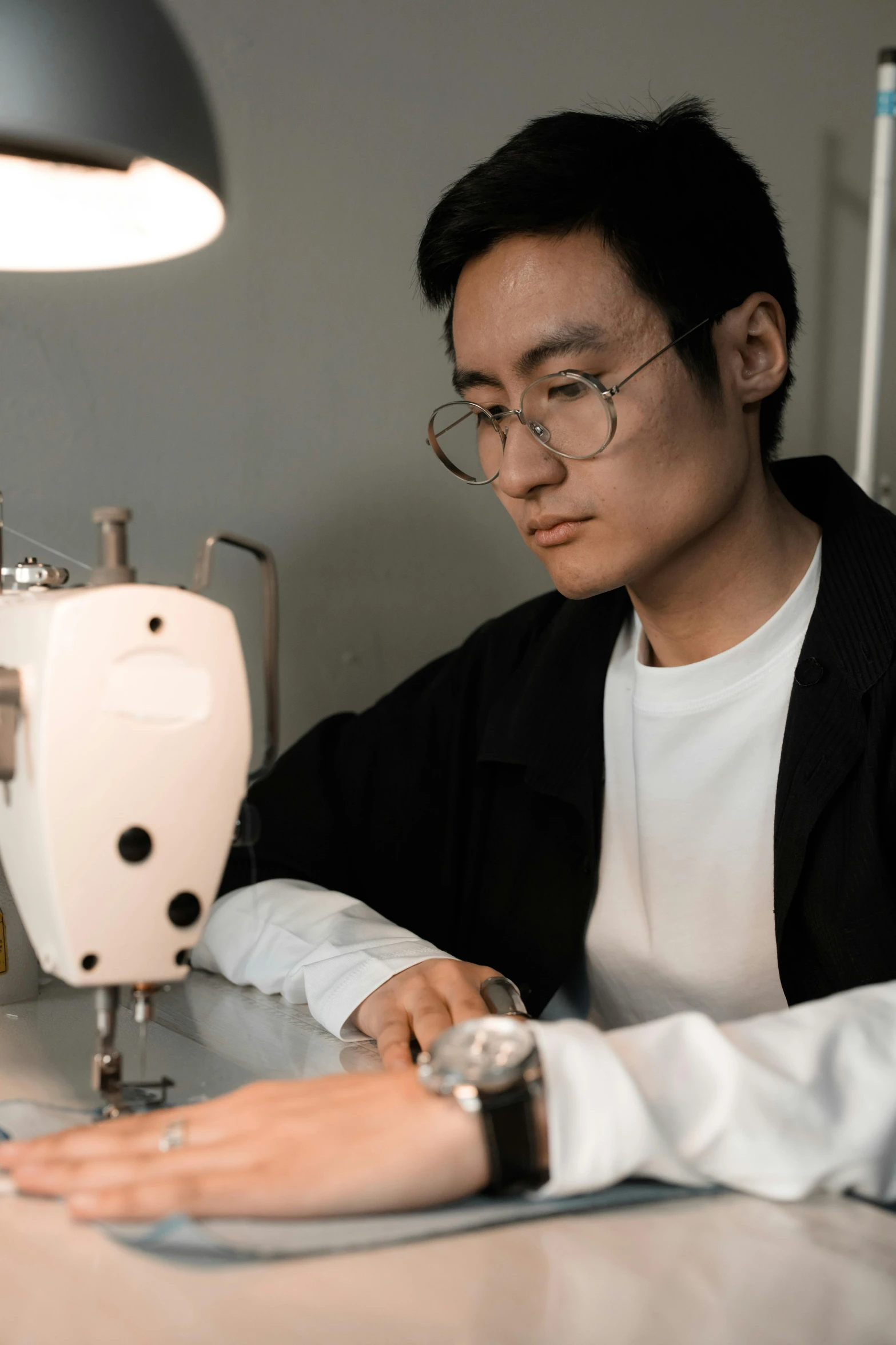 a young man working on a sewing machine