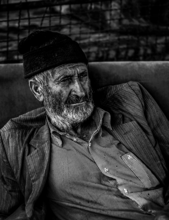 a man wearing a hat is sitting on the couch