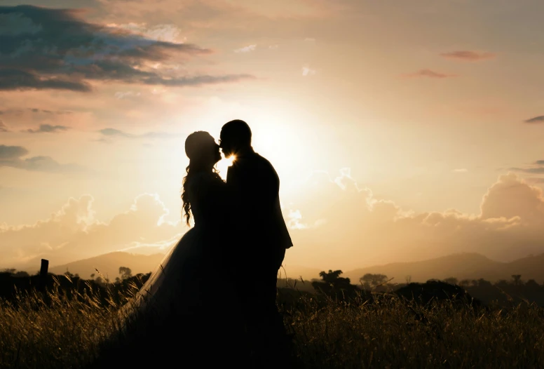 a couple in their wedding dress are under the sunset