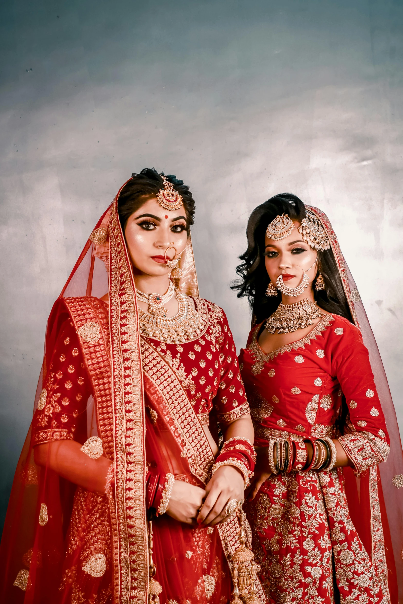 two women in wedding attire posing for the camera