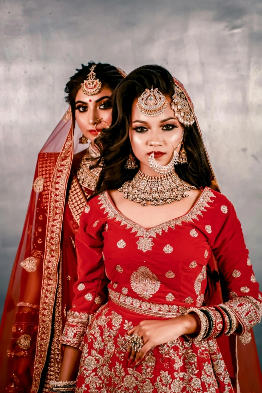 two women dressed up in red clothes standing next to each other