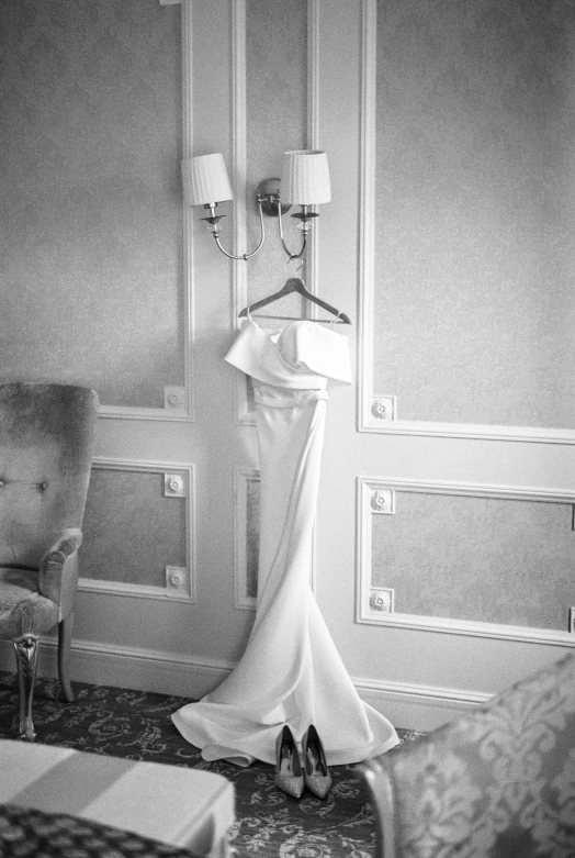 a dress hanging on the side of a bed