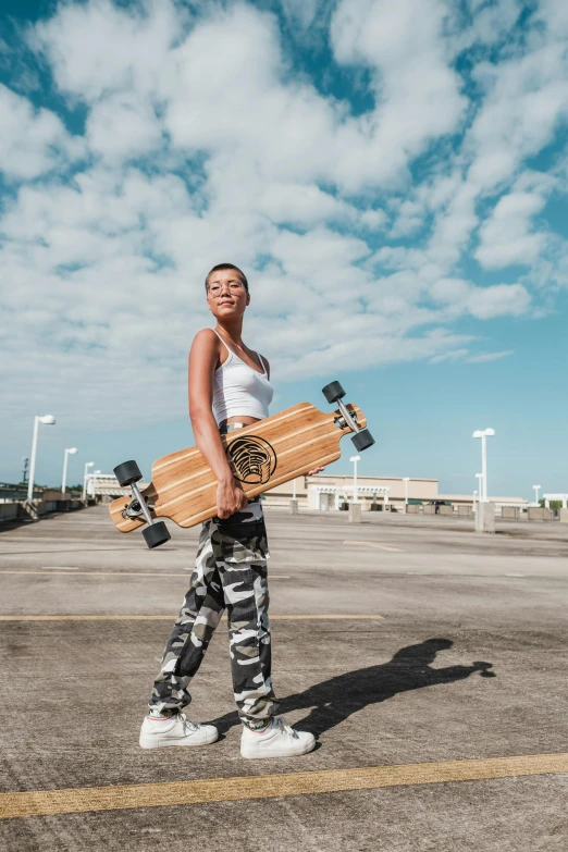 a woman holds two skateboards while walking through a parking lot