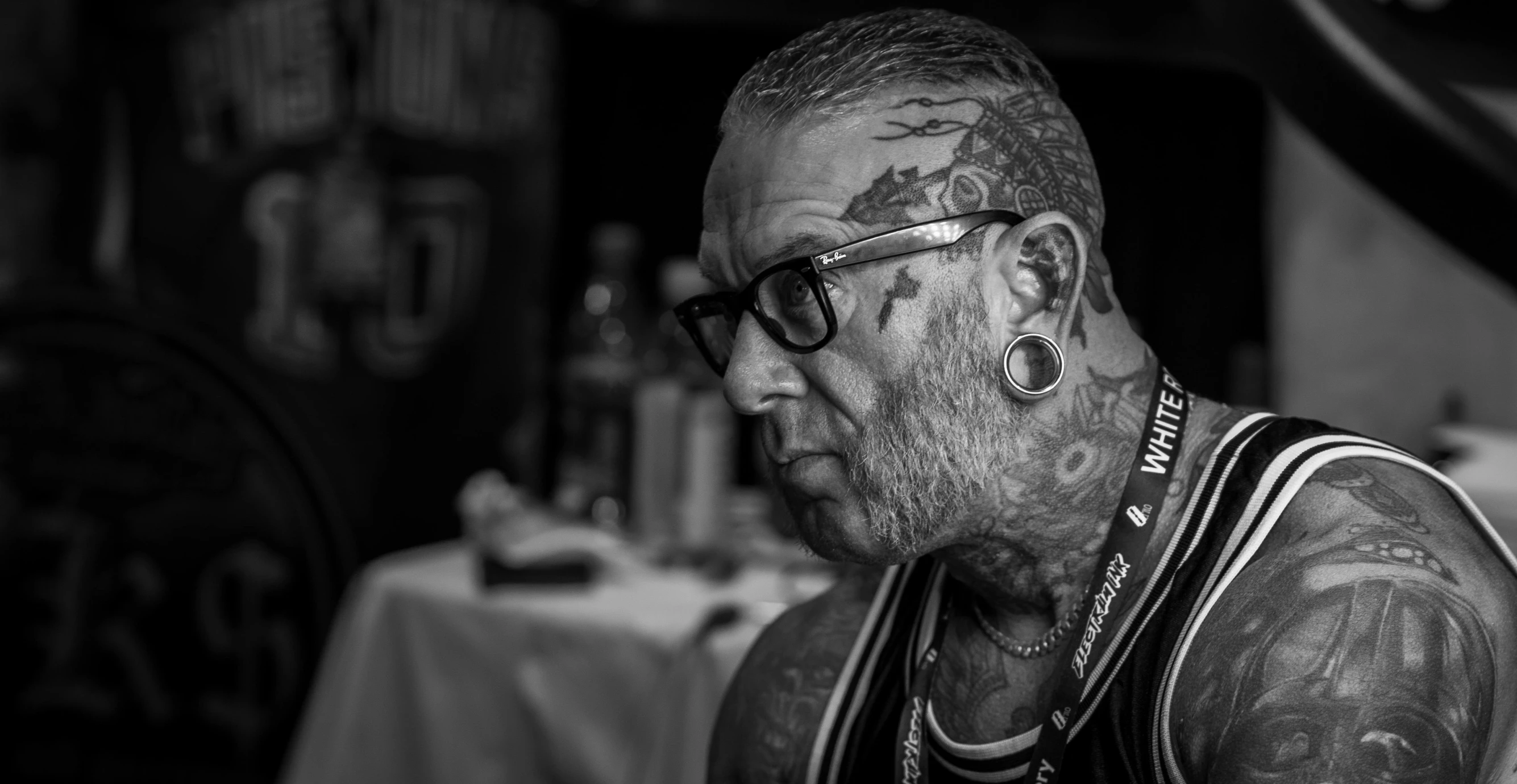 a man wearing glasses has tattoos on his face