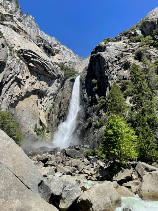 a waterfall is seen from across the valley