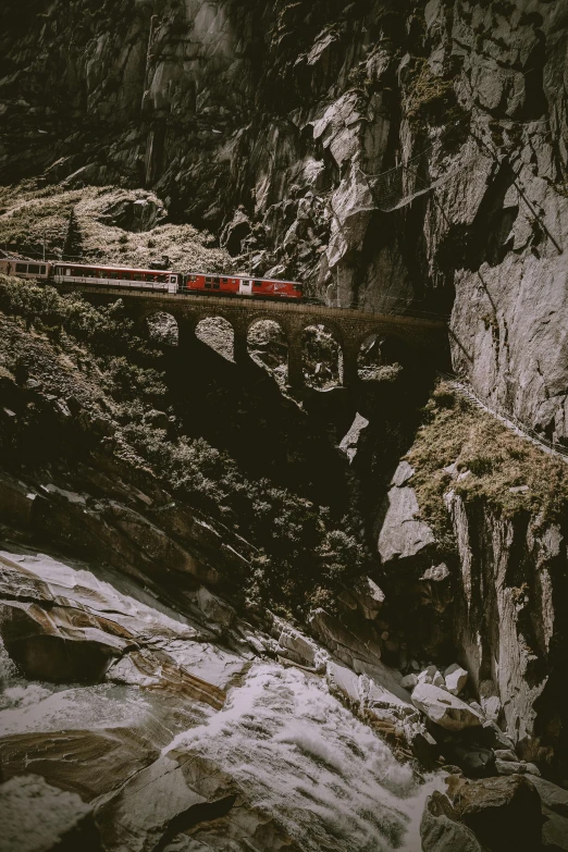 a train on tracks above some snow covered rocks