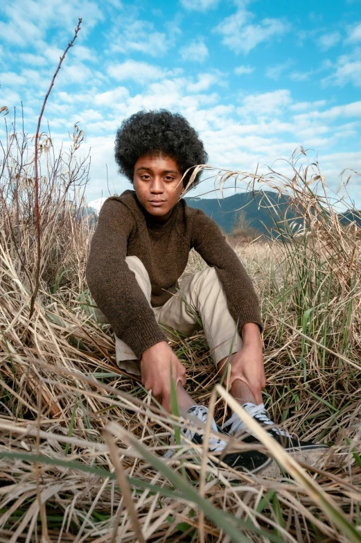 a  poses on a grass and bushes