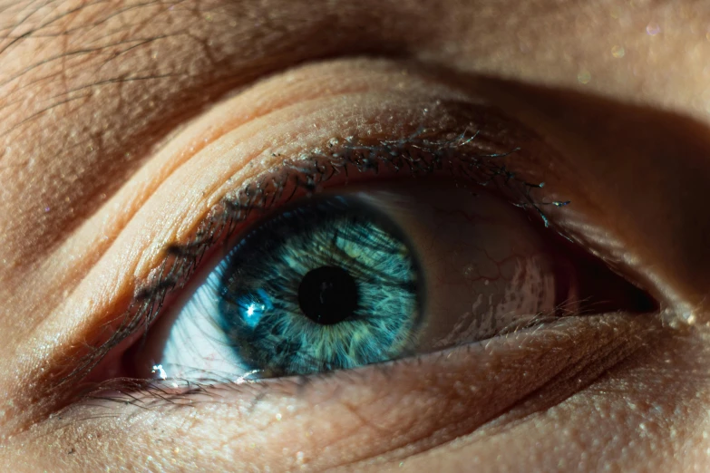 an extreme close up of the eye of a blue eyed person