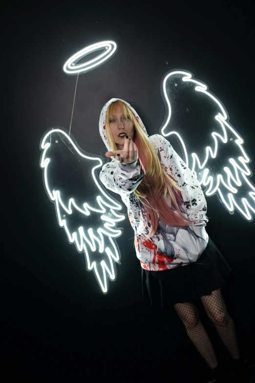 a girl with an angel wings sweater in a dark area