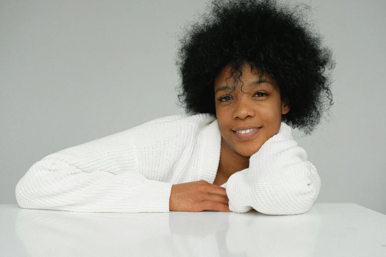 a woman leaning on a table posing for a picture