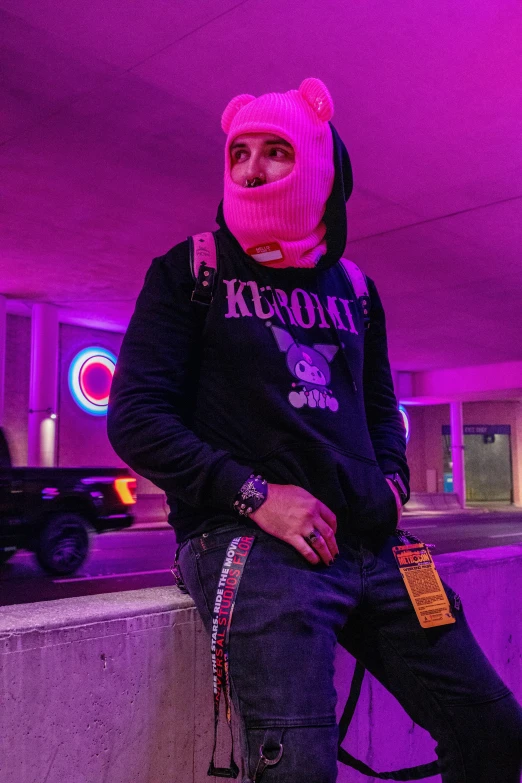 a woman with a pink hat sits on the curb