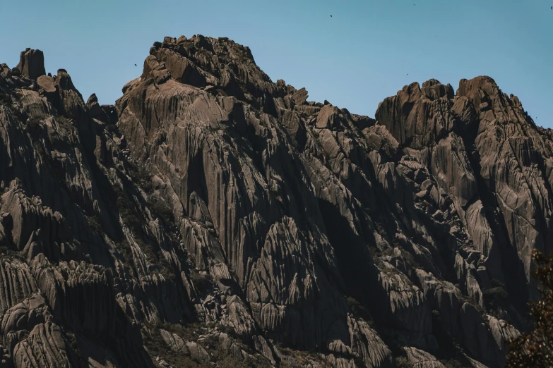 a bird is flying over a rocky mountain