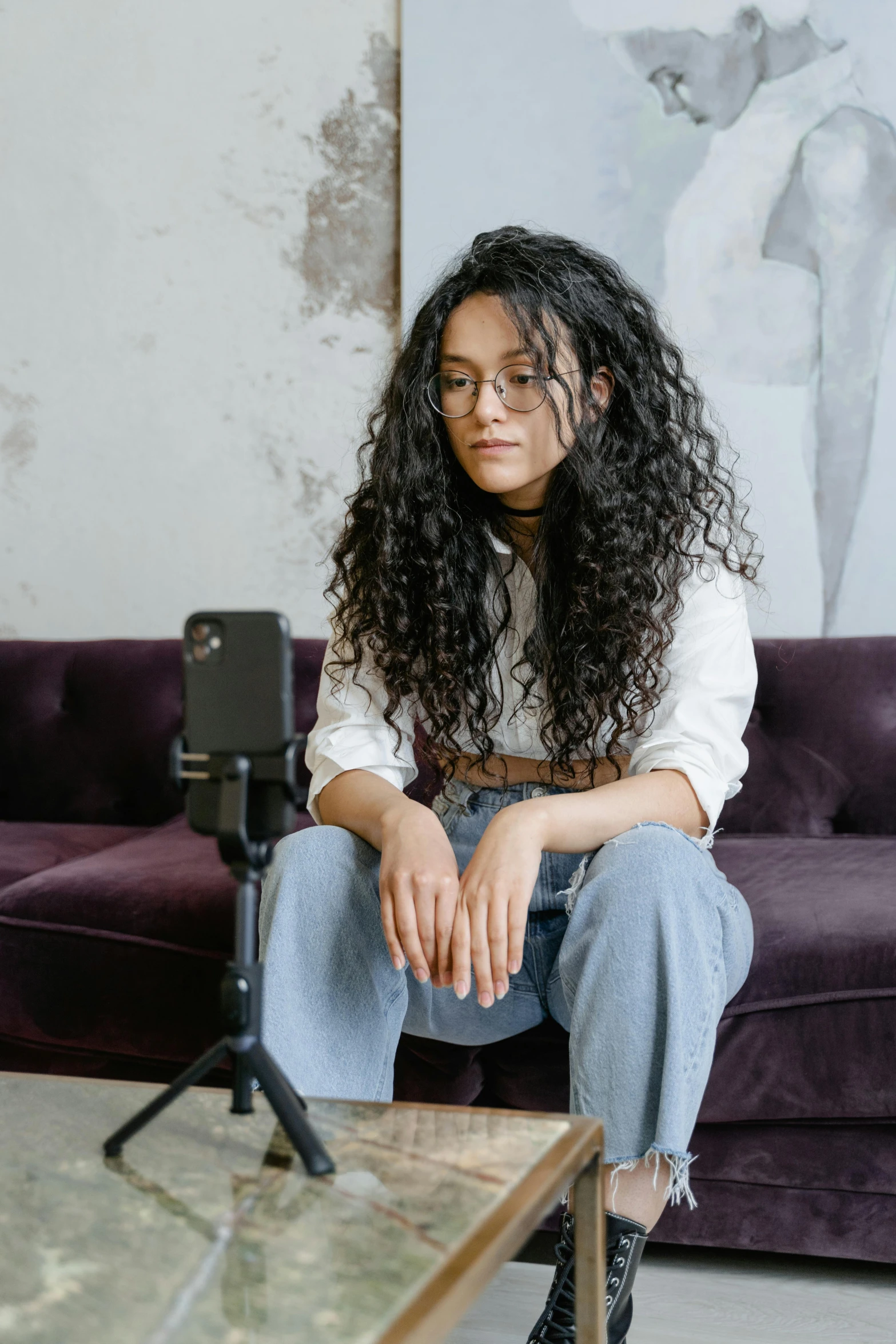 a girl sitting on a table looking into the camera