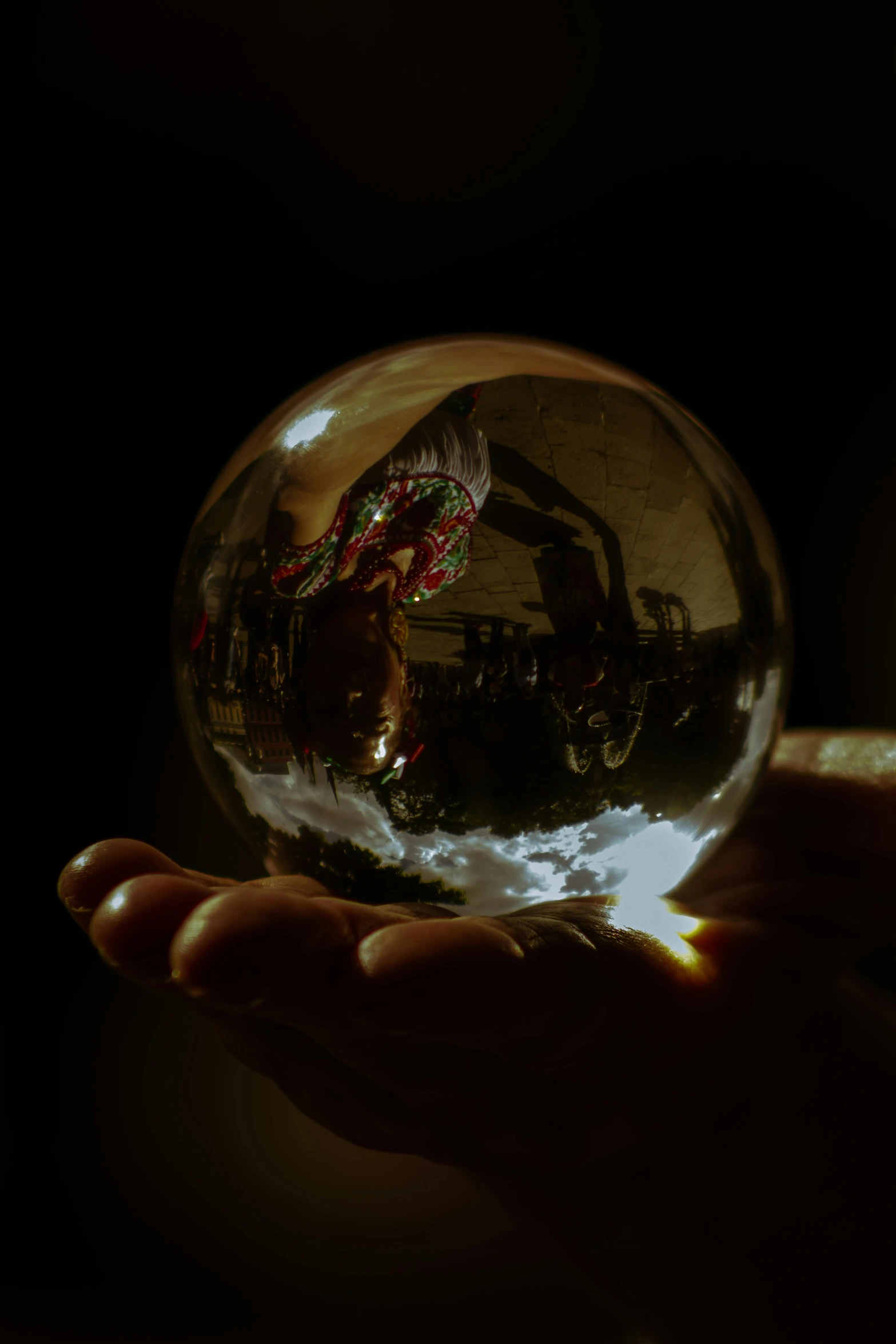 a hand holding a glass ball in the dark