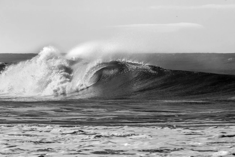 a surfer riding an ocean wave with white foam