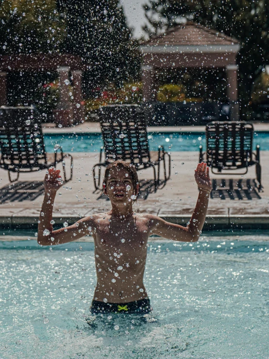 a shirtless man is in the pool while holding a paddle