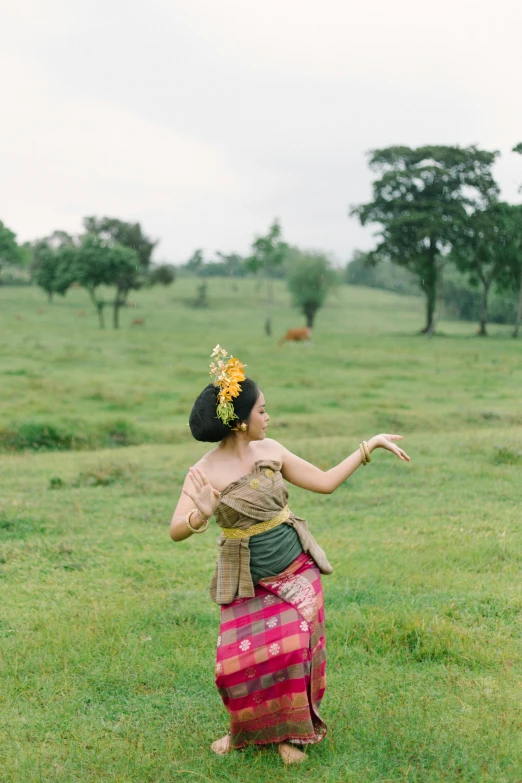 a young lady in a colorful skirt in an open field