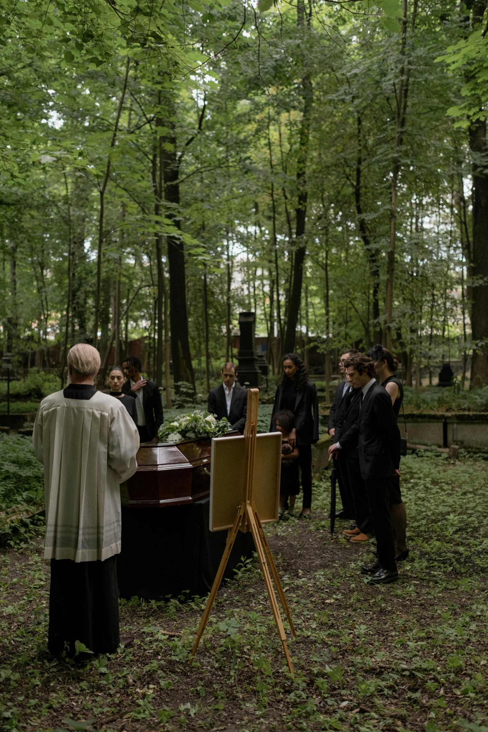 people in black suits standing outside in the forest