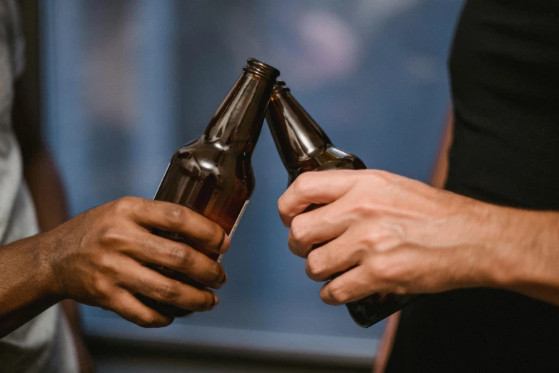 the man holds two empty beer bottles