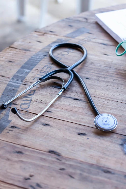 stethoscope and a folder laying on top of a wooden table