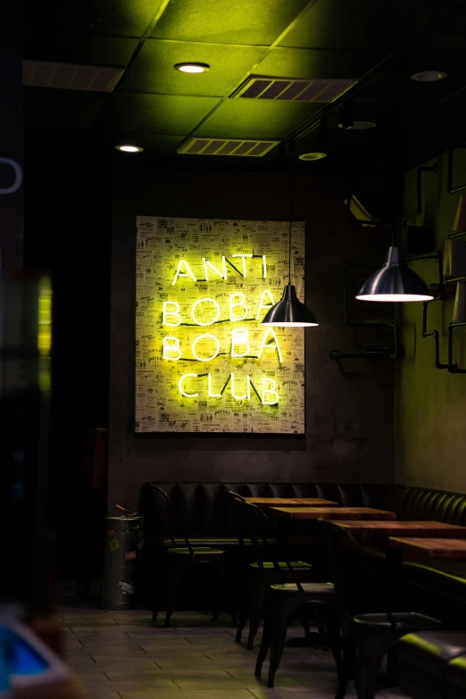 some tables chairs lights and a neon sign