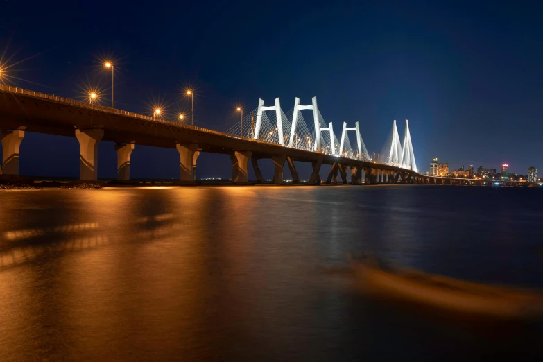 a night time scene of an overpass with the city lights in the background