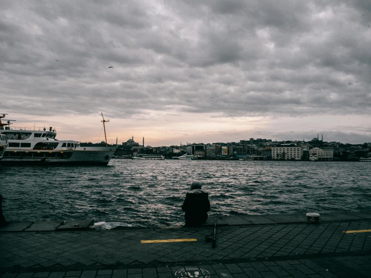 someone sitting and looking out at the water