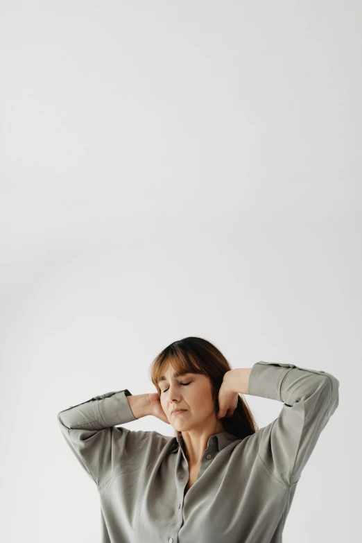 a woman in grey shirt standing with her hands on the hair