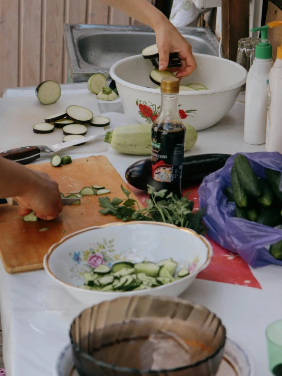 a woman preparing food in a bowl on top of a table