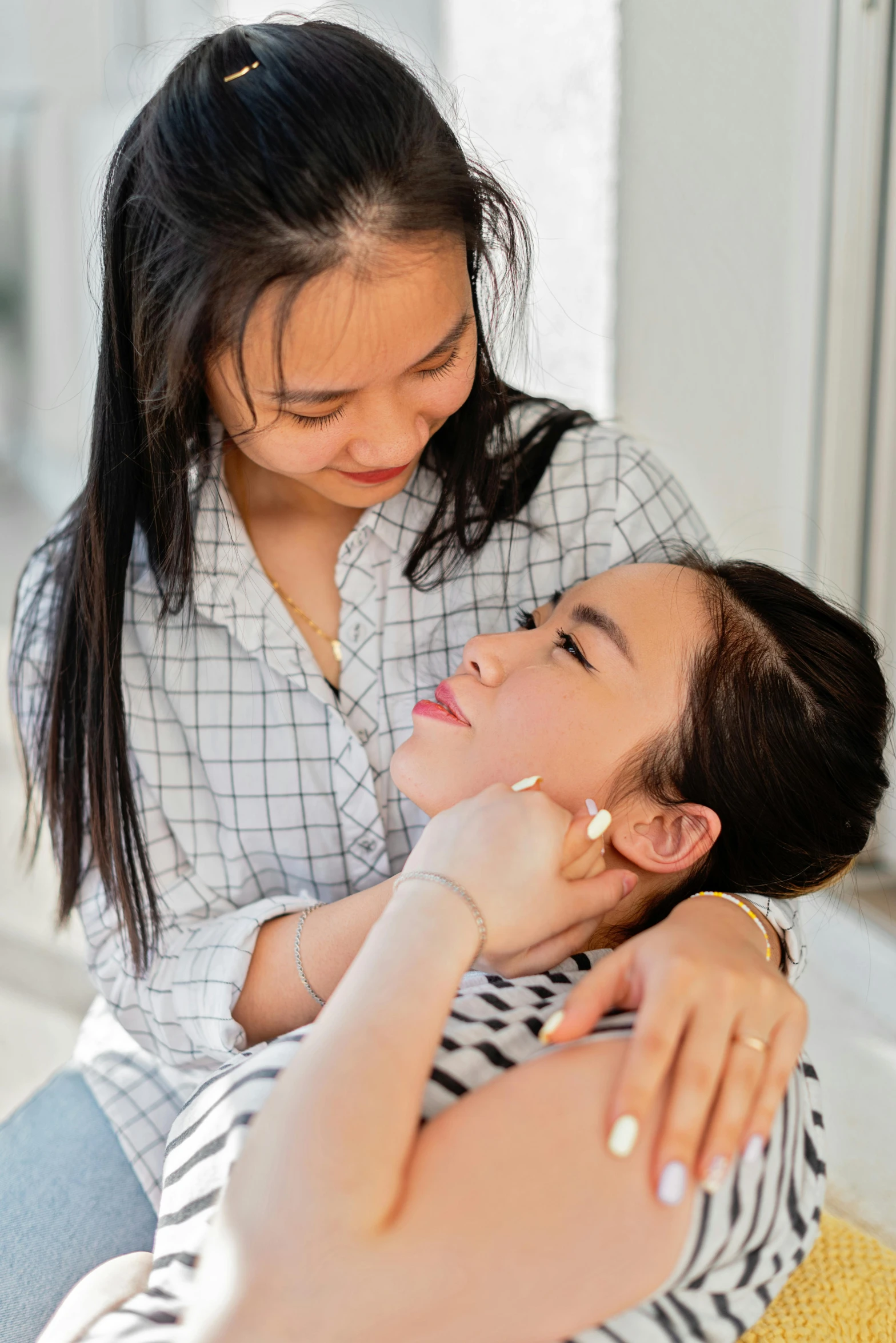 two women are hugging while one looks at the other's watch