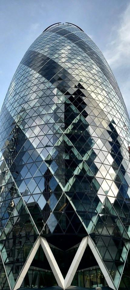 a tall building with mirrored windows and two pointed towers