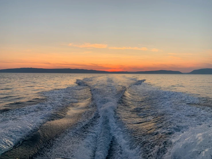 the wake of a ferry boat as it speeds across the water