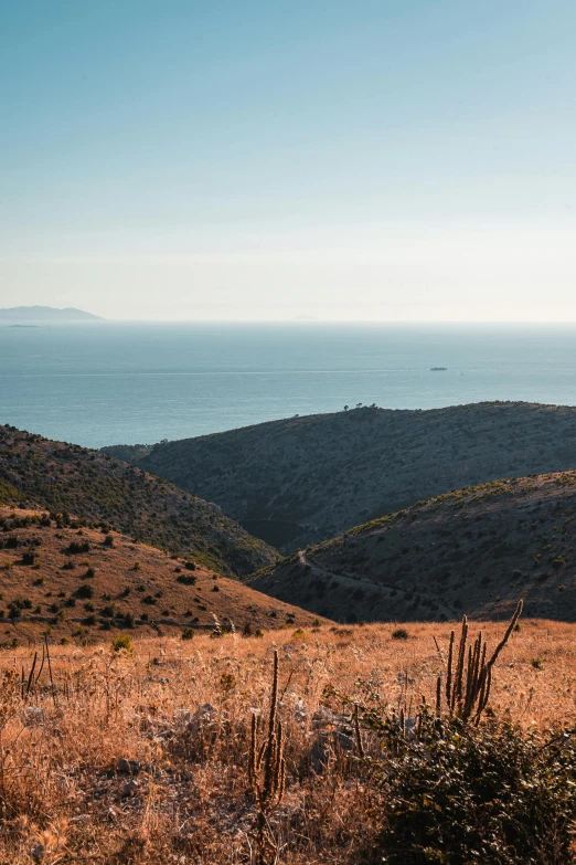 the sea sits beyond a vast landscape of desert terrain