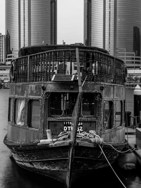 a old ship in a harbor with some towers behind it