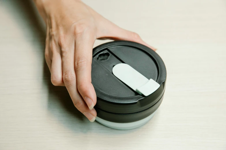 a person with their hand on a canister
