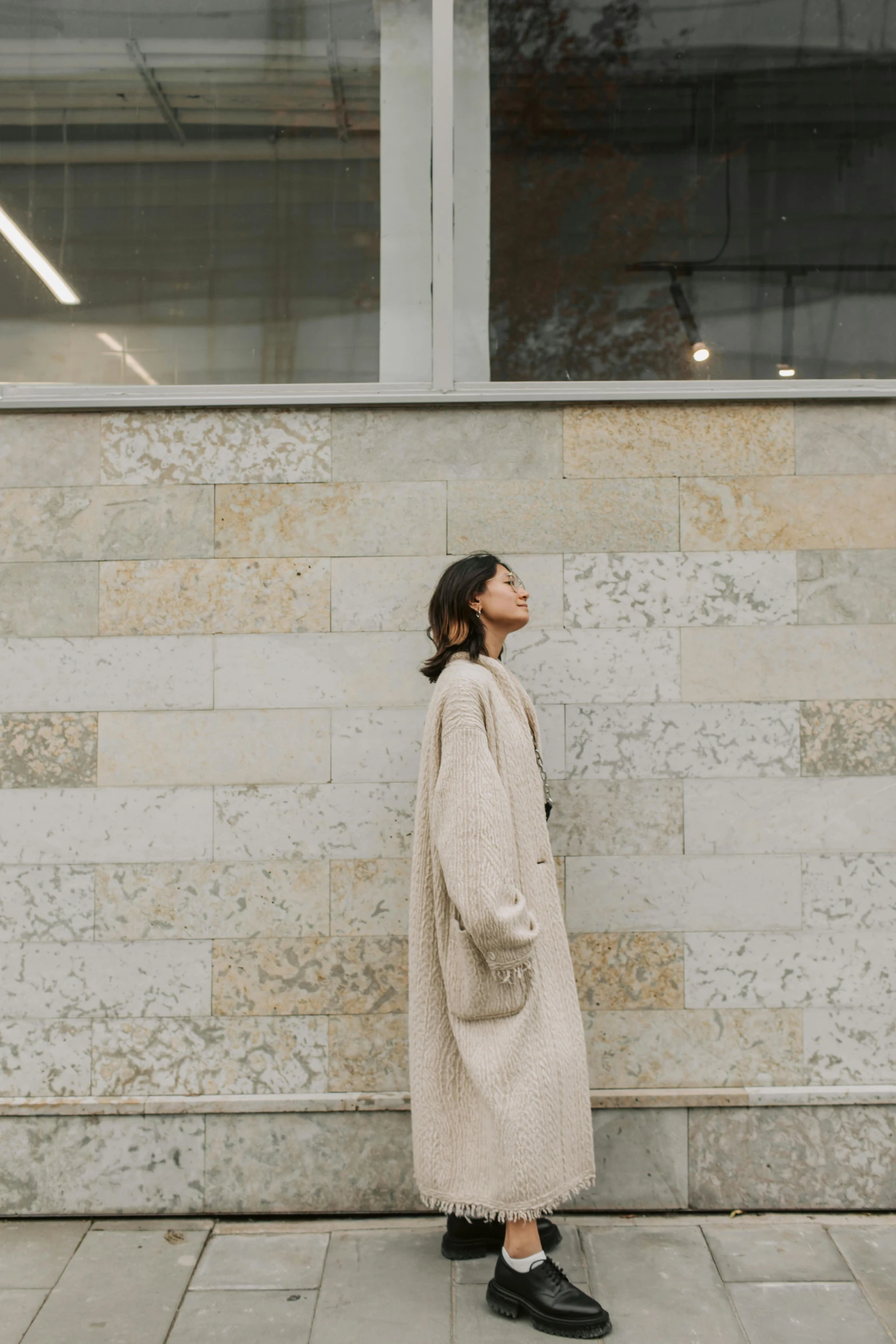 a woman leaning against a wall in an open air space