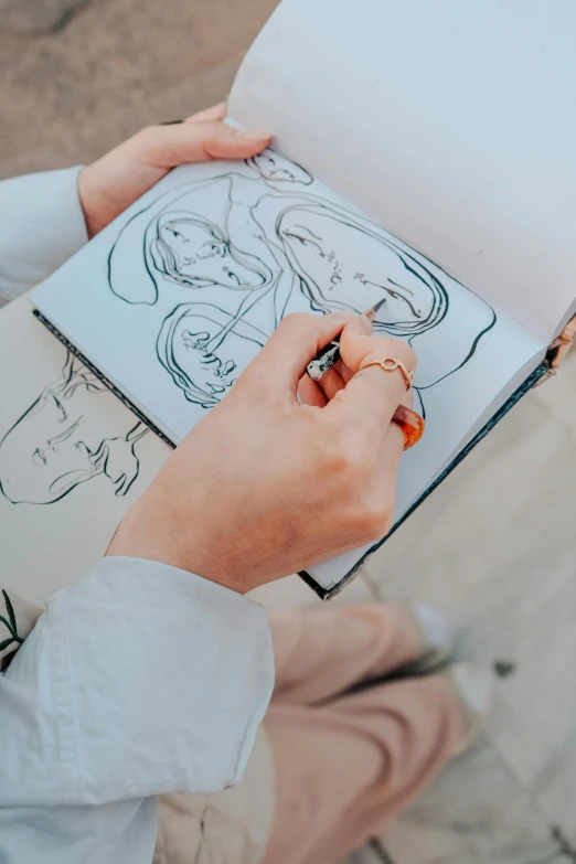 a person is drawing on a white piece of paper
