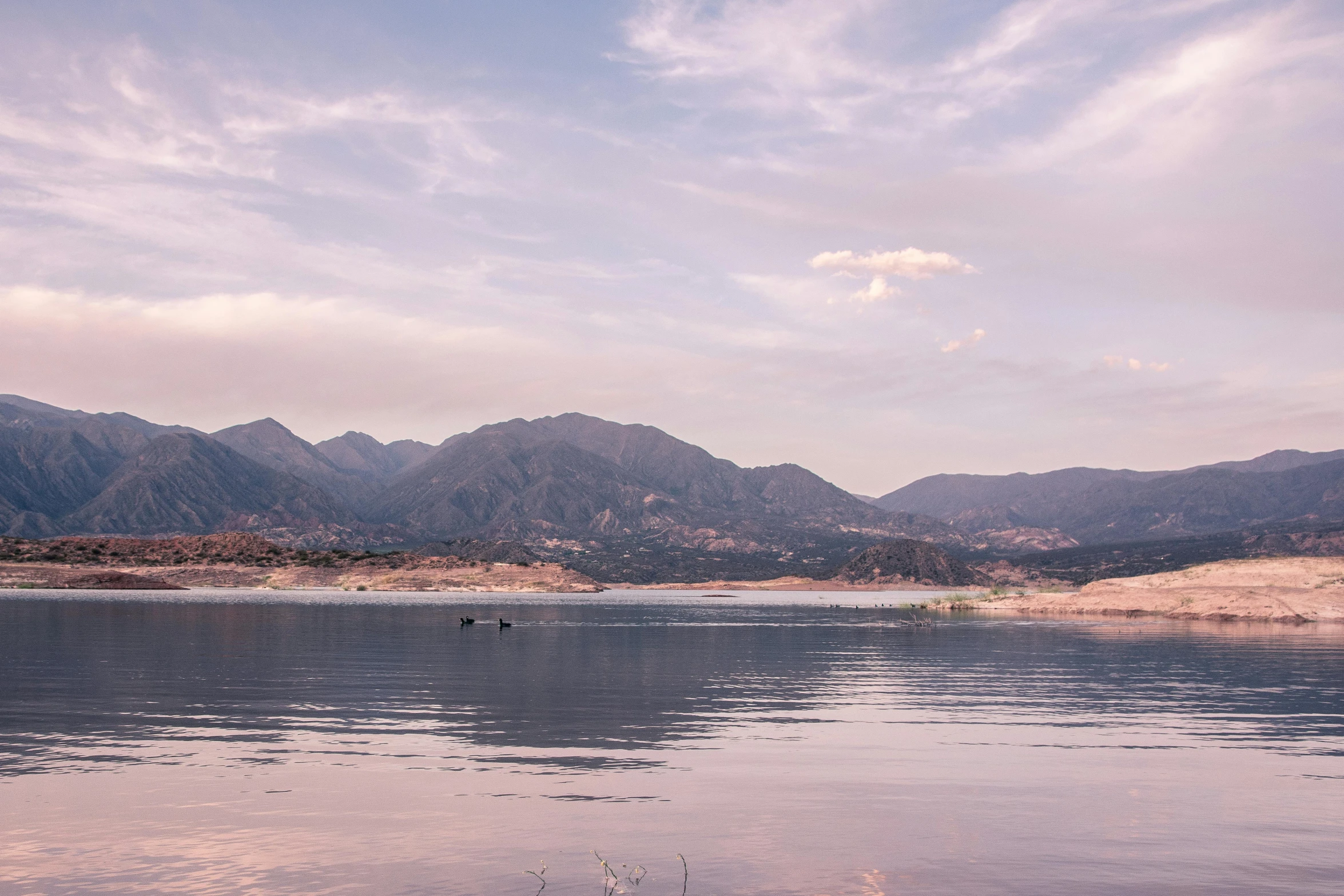 a body of water with mountains in the background