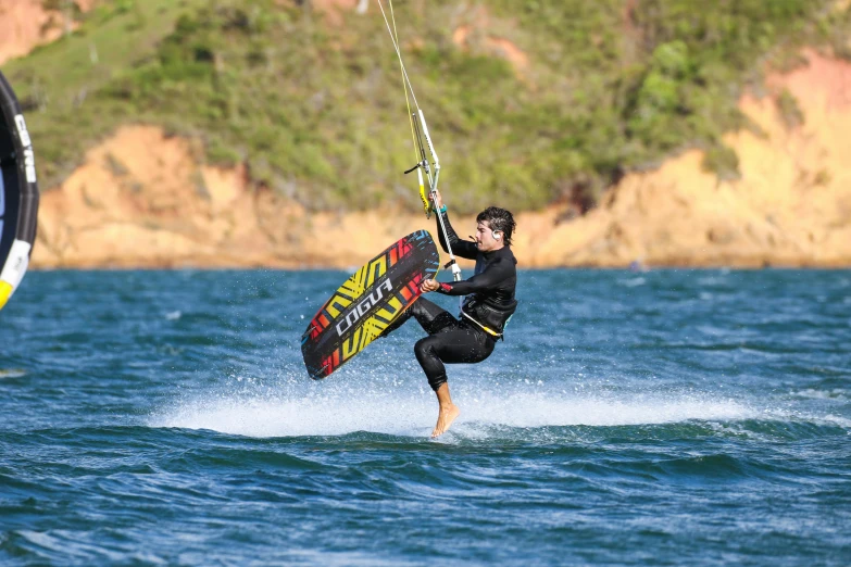 a guy in the ocean is holding on to a parasailing harness