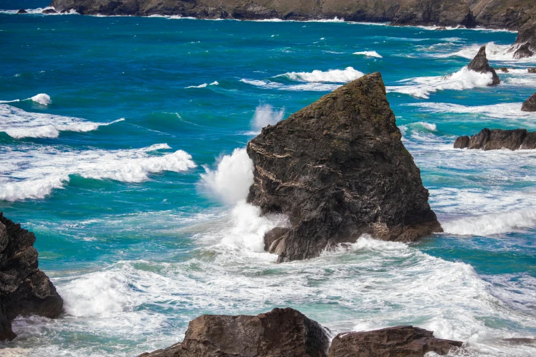 some very big rocks and water by the shore