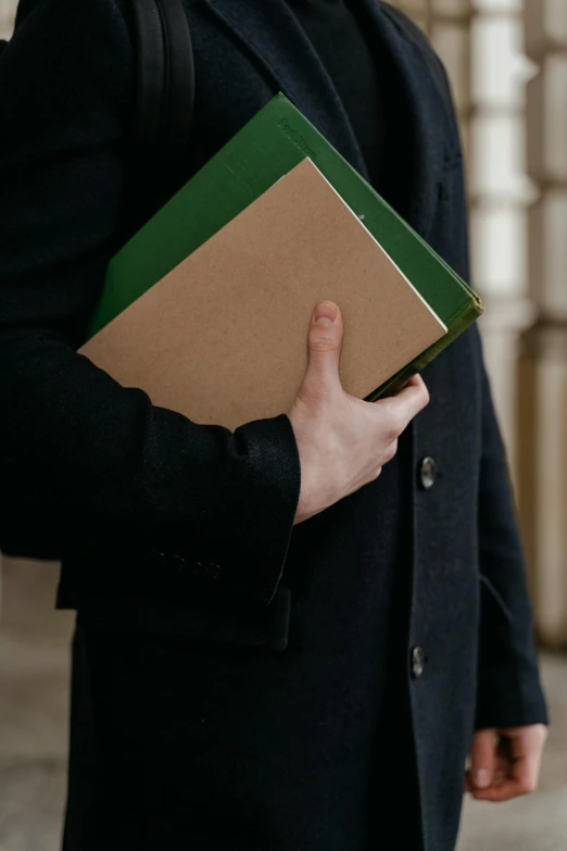 a person wearing a coat is holding a folder