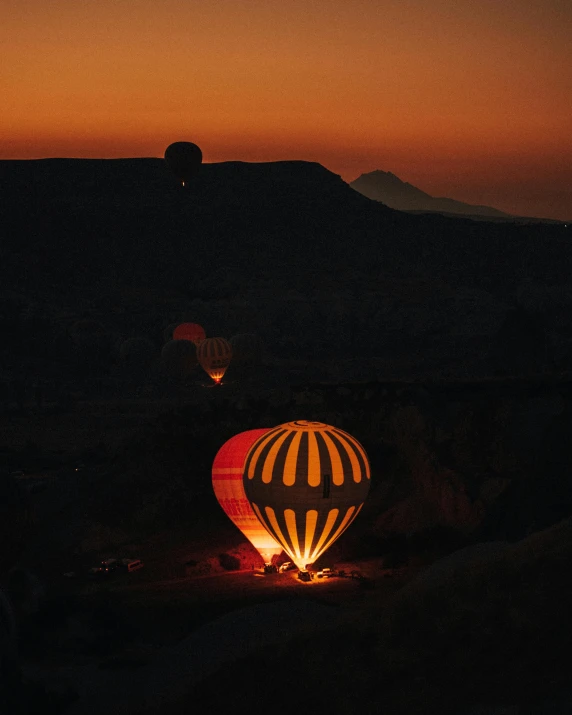 a  air balloon glowing red and white with a mountain in the background