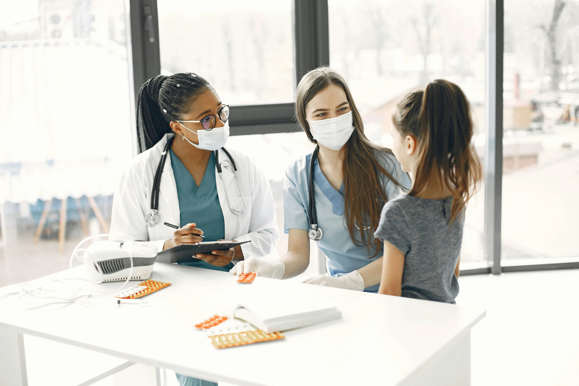 two nurses talking while looking at a clipboard