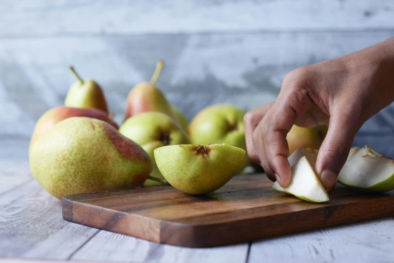 someone slicing apples with a wooden  board