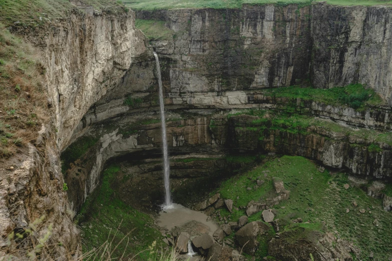 a tall waterfall sticking out from an area that has some green plants